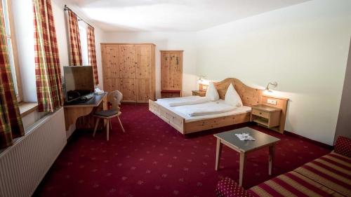 een hotelkamer met een bed en een tafel bij Hotel Vermoi in Laces