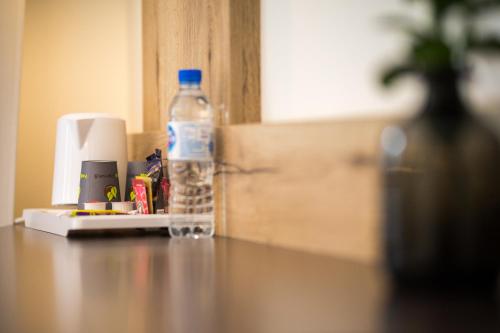 a bottle of water sitting on top of a table at Best Western Le Bois de la Marche in Poitiers