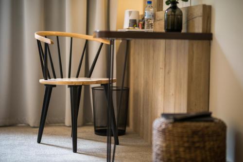 a wooden chair sitting next to a table at Best Western Le Bois de la Marche in Poitiers