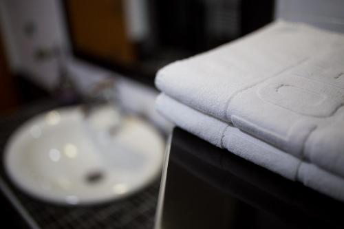 a pile of towels sitting on a counter next to a sink at F Apartmani Kragujevac in Kragujevac