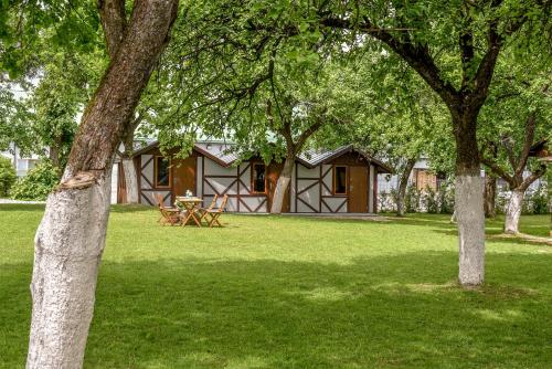 a cabin in the middle of a yard with trees at Rasos sodyba in Prienai