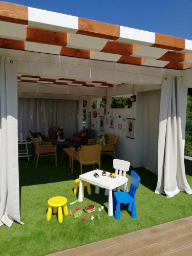 a play area with a table and chairs under a pavilion at Apartments Villa Katija in Drvenik