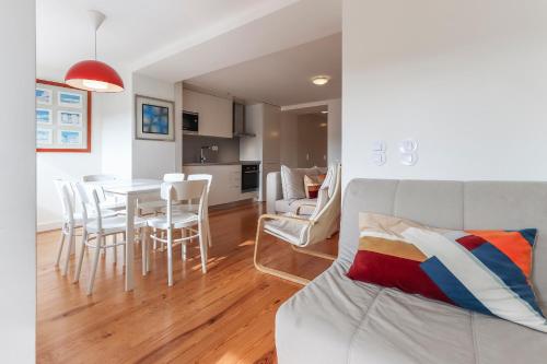 a living room and kitchen with a table and chairs at Principe Real T.M. Flat Charming View in Lisbon