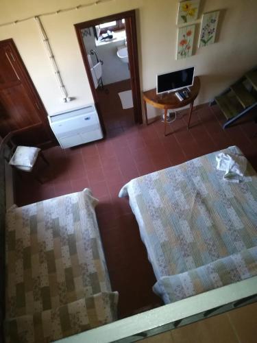 a room with two beds and a desk and a mirror at Locanda Dei Cocomeri in Montalto Uffugo