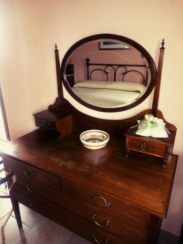 lustro na komodzie z łóżkiem w obiekcie Cortebella B&B Rimini w mieście Vergiano