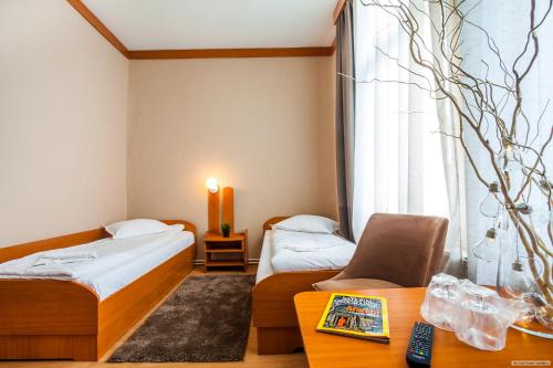 a hotel room with two beds and a table at Szilagyi Hotel&Restaurant in Gheorgheni
