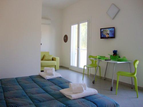 1 dormitorio con 1 cama y 1 mesa con sillas en Iride Guest House, en Oristano