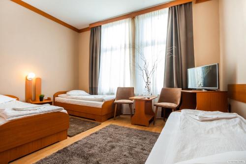 a hotel room with two beds and a tv at Szilagyi Hotel&Restaurant in Gheorgheni
