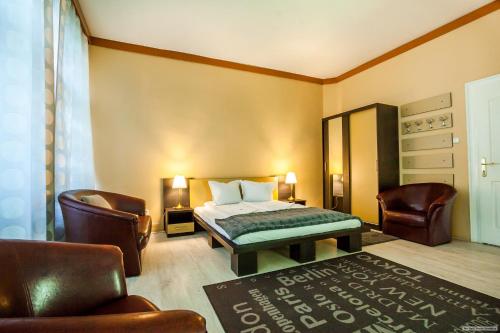 a bedroom with a bed and a couch and chairs at Szilagyi Hotel&Restaurant in Gheorgheni
