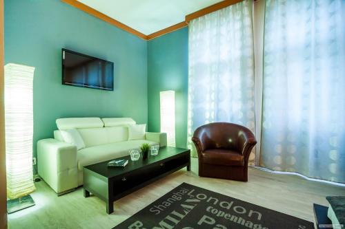 a living room with a couch and a chair at Szilagyi Hotel&Restaurant in Gheorgheni