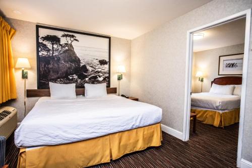 a hotel room with two beds and a mirror at Pelican Inn in Monterey