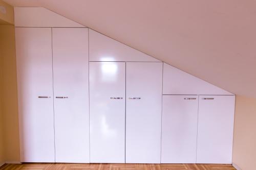 a row of white cabinets in a room at F Apartmani Kragujevac in Kragujevac