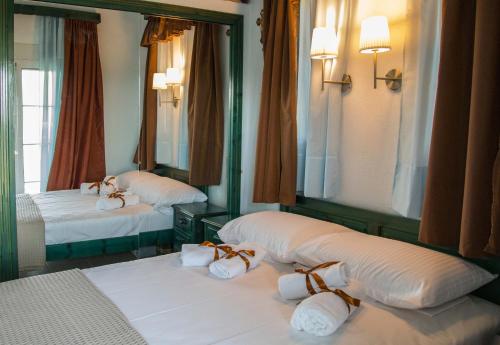 two beds in a room with mirrors and towels at The L Villa in Nea Peramos