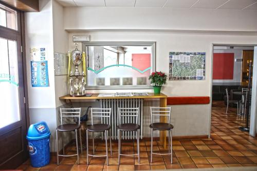 eine Bar in einem Restaurant mit vier Stühlen in der Unterkunft Albergo Gusmeroli in Tirano
