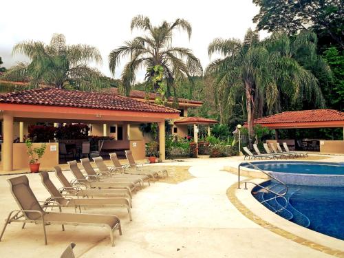 a group of chairs sitting next to a swimming pool at Dream Site near Punta Leona in Jacó