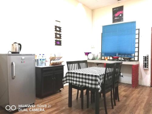 a kitchen with a table and chairs and a refrigerator at Alsafffa Homestay in Pantai Cenang