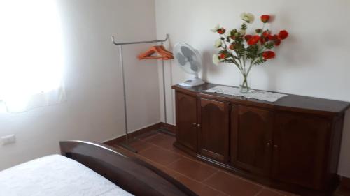 ein Schlafzimmer mit einer Blumenvase auf einem Schrank in der Unterkunft Su Pasciale in Nulvi