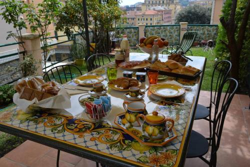 une table avec de la nourriture dessus sur un balcon dans l'établissement ilGirasole b&b, à Rapallo