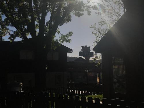 a silhouette of a house with a fence and a tree at Caboose Motel & Gift Shop in Durango