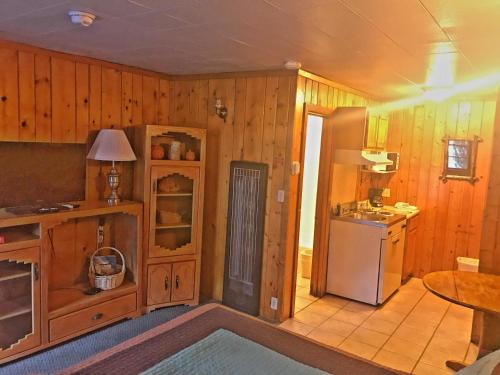a kitchen with wooden walls and a refrigerator and a table at Caboose Motel & Gift Shop in Durango