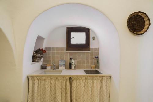 un baño con lavabo y espejo en Il Trullo del viaggiatore, en Alberobello