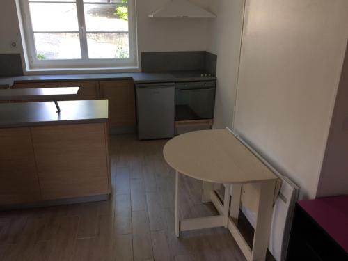 eine kleine Küche mit einem Tisch und einem Fenster in der Unterkunft Guitte family in Poilly-sur-Serein