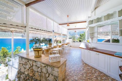 a large kitchen with tables and chairs and windows at Club Çapa Hotel in Kas