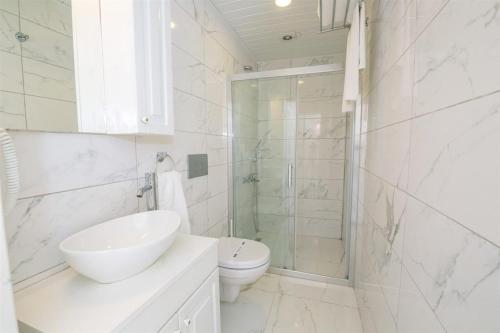 a bathroom with a sink and a toilet and a shower at Club Çapa Hotel in Kas