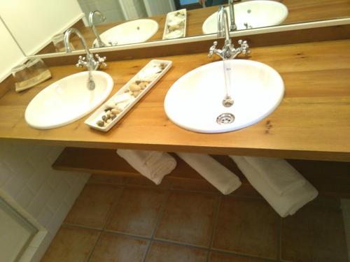 two sinks on a wooden counter in a bathroom at Casa Fidela in Lomeña