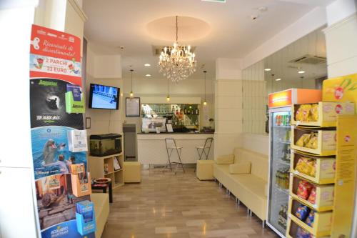 a grocery store with a chandelier and a room with a couch at Hotel Villa Caterina in Rimini