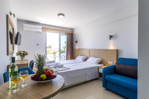 Una habitación de hotel con una cama y una mesa con un bol de fruta. en Paul Marie Hotel Apartments, en Ayia Napa