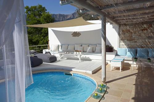 a patio with a swimming pool and an umbrella at Mare Monte Small Boutique Hotel in Chrysi Ammoudia