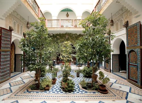 a courtyard with trees and plants in a building at Ryad El Borj in Marrakech