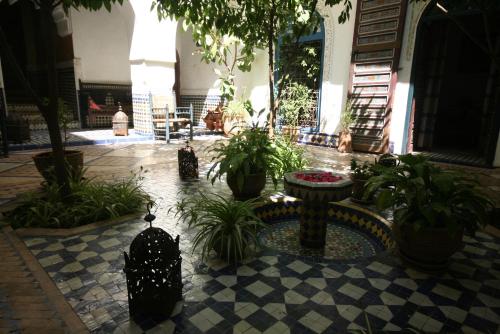 a courtyard with plants and a fountain in a building at Ryad El Borj in Marrakech