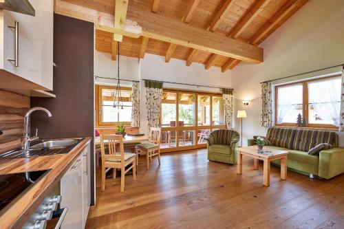 a kitchen and living room with wooden ceilings at Ferienhaus Alpinissimo in Oberammergau