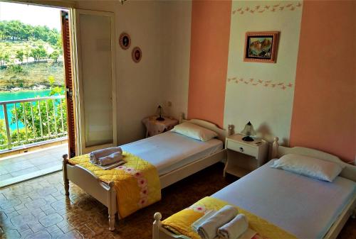 a bedroom with two beds and a balcony with a view at Magdalini in Votsi