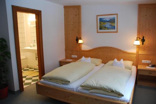a bedroom with a bed with two pillows and a mirror at Der Erlhof Restaurant & Landhotel in Zell am See