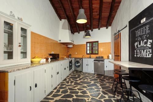 a large kitchen with white cabinets and a washer and dryer at Aleixo's House | Alentejo in Monforte