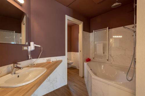 a bathroom with a sink and a tub and a shower at Villa Belvedere Hotel in Limone sul Garda