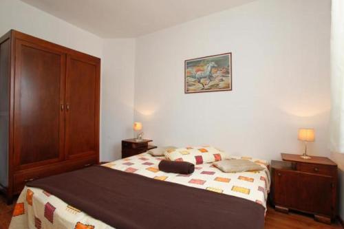 a bedroom with a bed and a wooden cabinet at Apartment Piranesi with a parking space in Pula