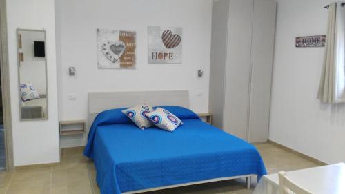 een slaapkamer met een blauw bed in een kamer bij Aria di Casa in Porto Cesareo