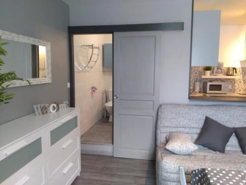 a living room with a couch and a bathroom at Les Studios proche du Mont Ventoux in Mazan