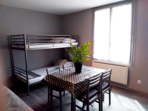 a dining room with a table and bunk beds at Les Studios proche du Mont Ventoux in Mazan