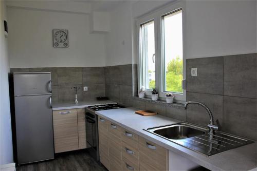 a kitchen with a stainless steel refrigerator and a sink at Apartment Piranesi with a parking space in Pula