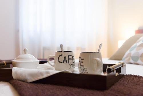 two coffee mugs sitting on a tray on a bed at Alojamiento Santa Maria in Milladoiro
