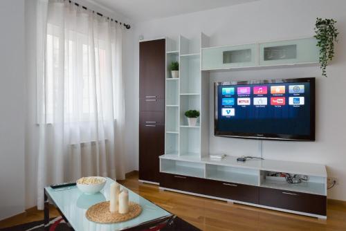 a living room with a tv and a table at Alojamiento Santa Maria in Milladoiro