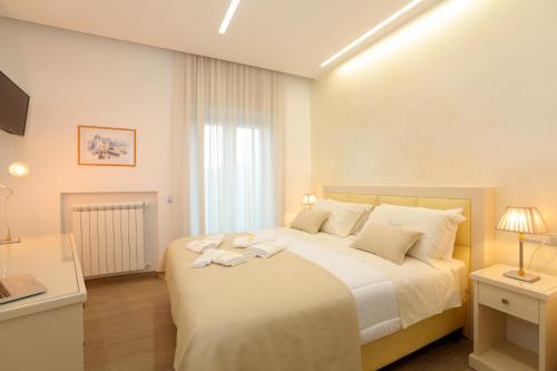 una camera da letto con un grande letto con lenzuola e cuscini bianchi di Relais Ohana ad Arola