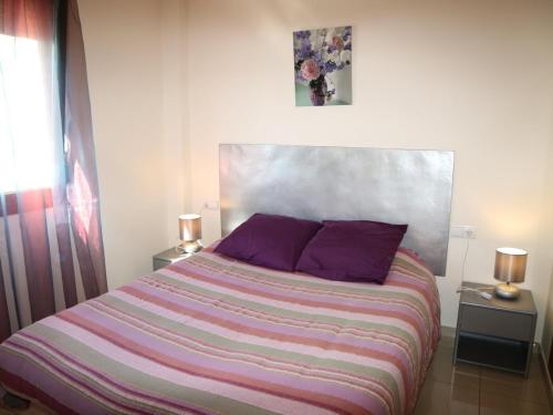ロザスにあるMIL.LENI III 1 2 4のベッドルーム1室(大型ベッド1台、紫色の枕付)