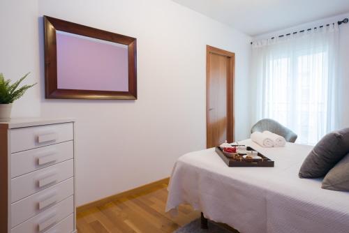 a bedroom with a bed with a mirror and a dresser at Alojamiento Santa Maria in Milladoiro