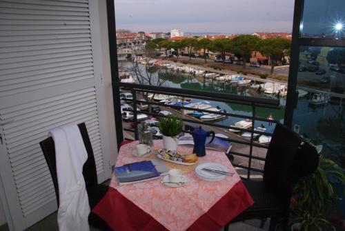 a table on a balcony with a view of a marina at Residence Aprilia in Grado
